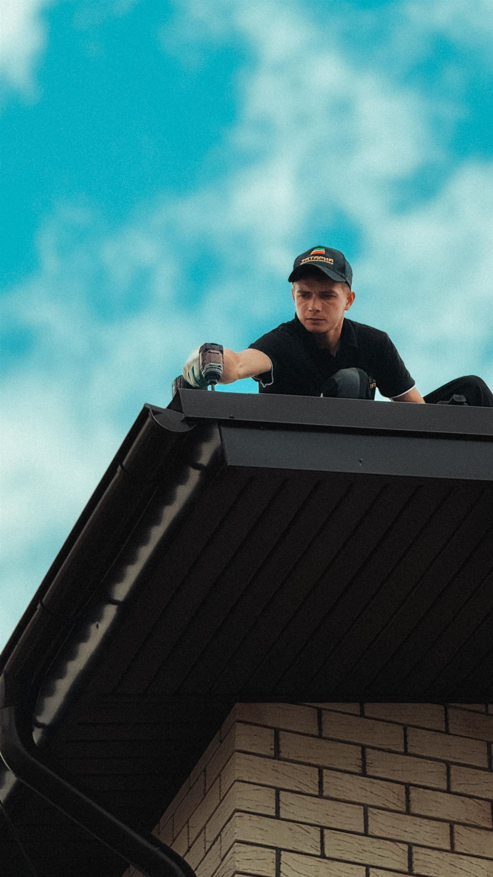 Roofer replacing coastal grade metal flashing and panels on an Amelia Island roof