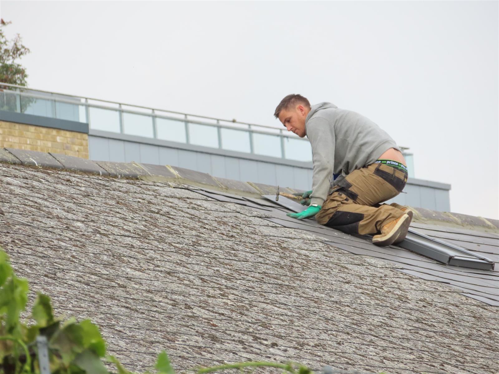 Roofer inspecting an aging shingle roof in a Fleming Island community